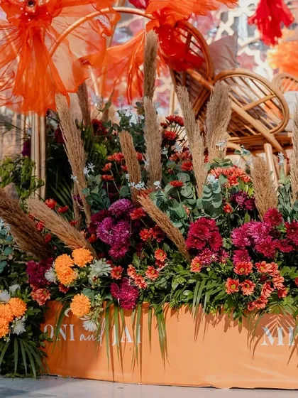 The base of the stage was decorated with a lush arrangement of florals and pampas grass in terracotta and burgundy tones.