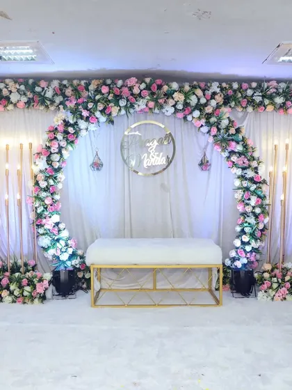 Another beautiful engagement stage setup, this time with elegant candle-like light stands on either side of the main arch, adding a warm glow to the atmosphere.