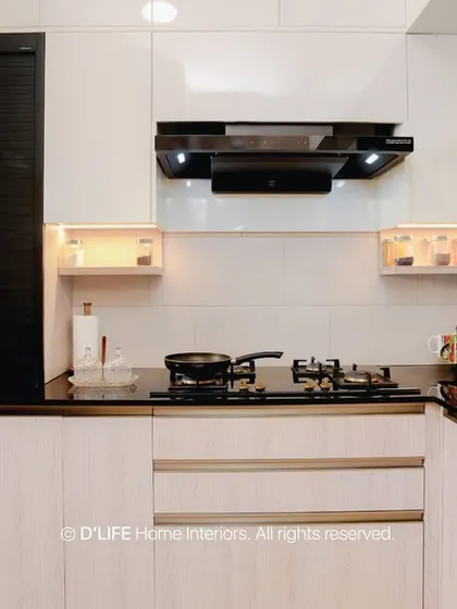 This sleek modular kitchen combines white gloss cabinets with dark accents for a clean, modern look. Integrated appliances and smart storage solutions ensure the space is as functional as it is beautiful.