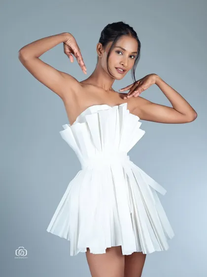 A joyful and energetic pose in the paper dress. The model's expression and the unique outfit combine to create a memorable and happy fashion portrait.