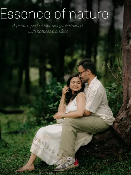 A beautifully framed shot of a couple sitting by a tree in a forest, capturing a moment of quiet intimacy.