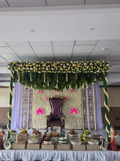 A straight-on view of the half-saree ceremony stage, showing the purple throne and symmetrical decor.