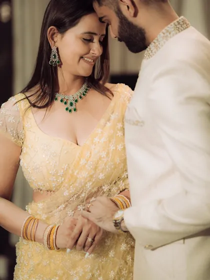 A close-up portrait focusing on the quiet intimacy between the couple. This shot highlights their elegant traditional attire and the gentle connection they share, perfect for an engagement album.