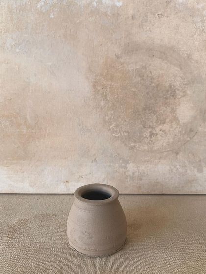 A small, raw pot, perfectly centered and ready for its next stage.