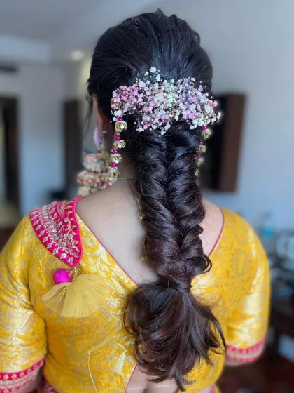 Another shot of the messy fishtail braid, showing the texture and the vibrant floral arrangement.