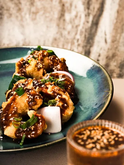 A plate of crispy fried prawns tossed in a savory, nutty sauce and garnished with sesame seeds. This dish brings a touch of Asian flavor to my catering menu.