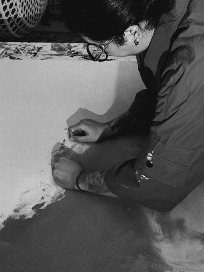 My work is intimate, intentional, and emotional. This black and white shot captures a moment of intense focus as I work on a large canvas, connecting with the piece through touch.