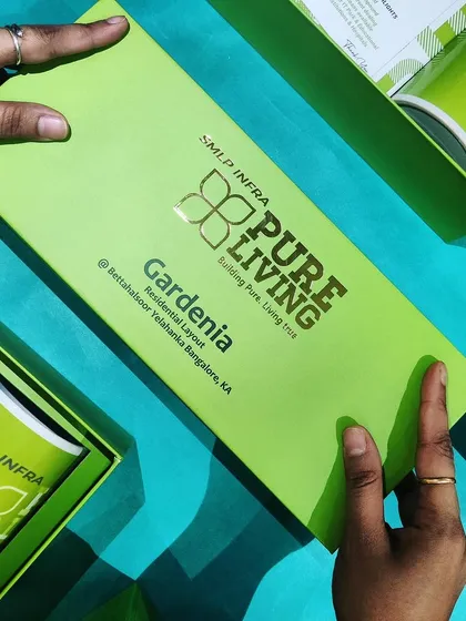 A vibrant and fully branded welcome kit for SMLP Infra. This bright green box features their logo with gold foil stamping and contains custom-printed mugs and other branded merchandise, making a bold first impression.