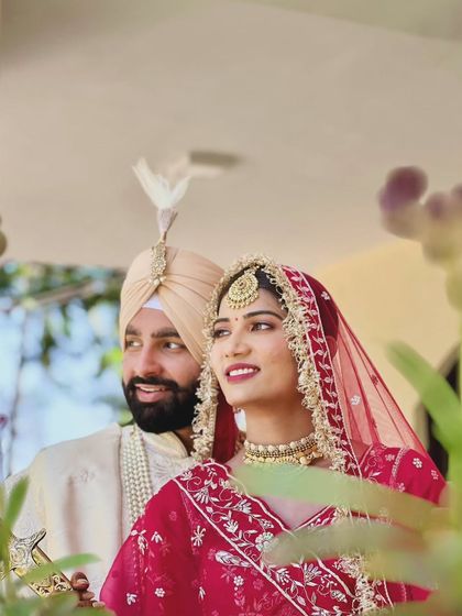 A candid, over-the-shoulder shot of a beautiful Sikh bride during her Anand Karaj ceremony. Her expression is one of serene happiness.