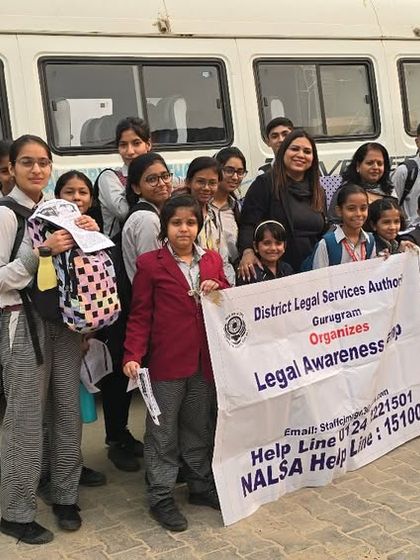 A happy group of schoolchildren posing with our legal awareness banner in front of the mobile van. Educating children about basic laws and safety from a young age is a proactive step towards a better society.
