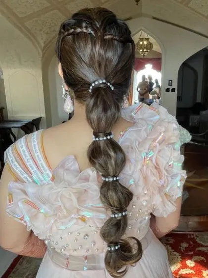 A heart-shaped braid leading into a bubble ponytail with pearl bands. This is a super creative and unique style for a fun-loving bride.