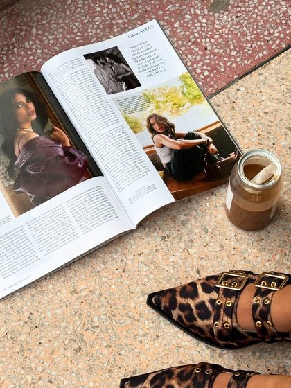 A flat-lay of my 'girl dinner': Vogue magazine and iced coffee. The leopard print shoes add a touch of my personal style, creating an aesthetic that's both chic and relatable.