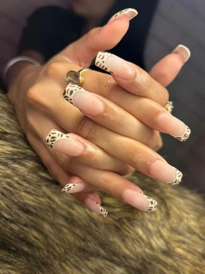 A different angle showcasing the hand-painted leopard print French tips, combining a classic shape with a bold pattern.