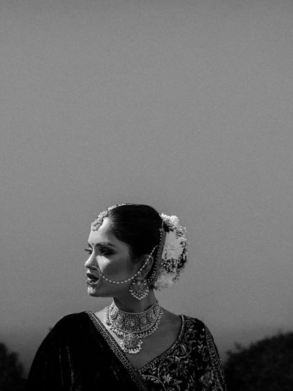 A stark and beautiful black and white profile portrait of a bride, focusing on her silhouette and traditional jewelry.
