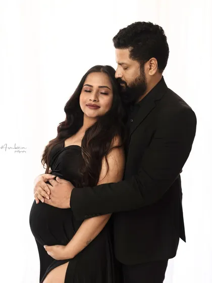Style and elegance in one frame. This couple's portrait in matching black outfits is modern, intimate, and sophisticated. The high-key lighting creates a clean and timeless look.