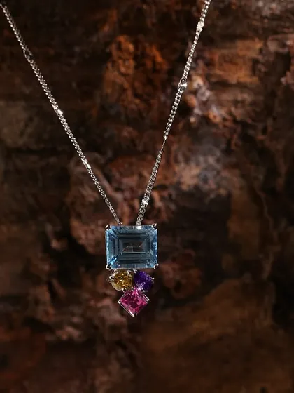 This multi-gemstone necklace is set against a natural wood background, allowing the vibrant colors of the stones to pop while maintaining an organic feel for the brand's lookbook.