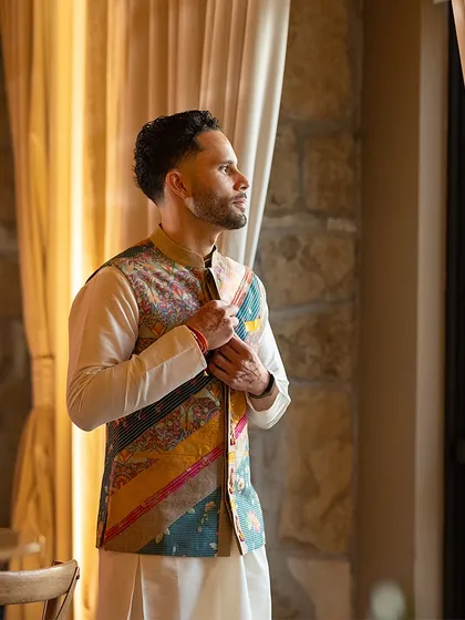 A quiet moment of anticipation. The groom's unique Nehru jacket, with its mix of prints and textures, is a testament to our belief in personalized, story-driven styling.