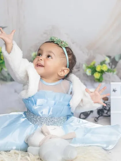 Another beautiful shot from Kridha's first birthday, celebrating with a sign and a happy, expressive pose.