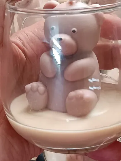 A close-up of a single teddy bear jar candle, showing the cute details of the bear sculpture.