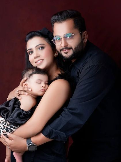 A slightly different pose from the same family session, showing the deep bond and affection as they embrace their new baby.