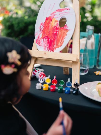 We make sure our little guests have fun too. During our anniversary brunch, a child enjoys a painting activity, adding a creative and family-friendly element to the celebration.