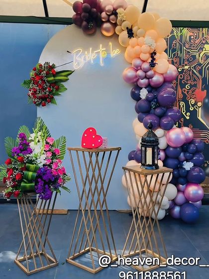 Perfect for a bridal shower or bachelorette party, this setup features a "Bride to be" neon sign, a modern balloon arch in rich colors, and elegant floral arrangements on geometric stands.
