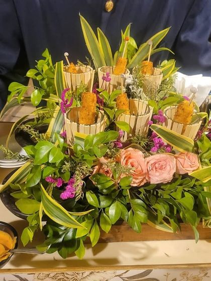 An appetizer tray designed to look like a miniature garden. Crispy cones are nestled amongst fresh greens and flowers, offering guests a delightful and whimsical bite.