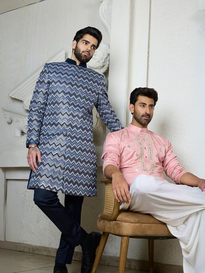 A showcase of two striking kurtas, one in a bold blue chevron pattern and the other in a soft pink with mirror work, demonstrating the range of styles I offer.