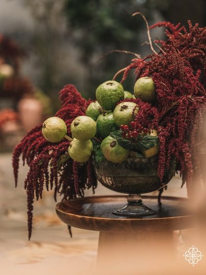 A centerpiece from the 'Orchard of Life' event, featuring guavas and red amaranthus.