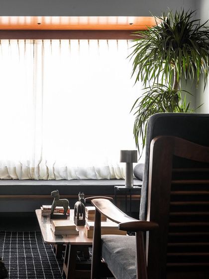 A detail shot of the living room, focusing on the custom coffee table and armchair. The play of textures, from the wood grain to the upholstery, is a key part of how I create warm and inviting spaces.
