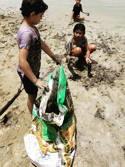 Together, the children gather the harvested clay into a large bag. This task requires teamwork and physical effort, teaching them the satisfaction of working collaboratively towards a common goal.