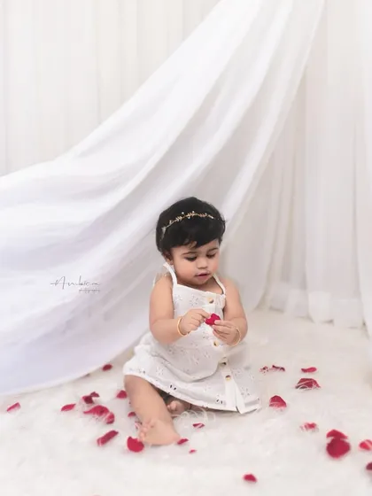 A simple and beautiful moment. This baby sits among rose petals, creating a classic and timeless portrait for her first birthday.
