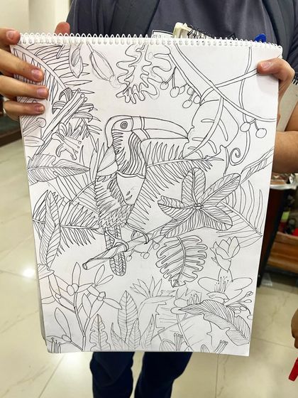 A close-up of the intricate line work in the toucan drawing, showcasing the student's focus and developing skill in detailed illustration.
