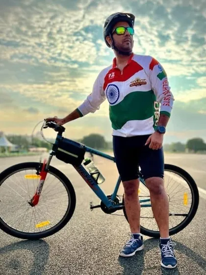 A member in our tricolor jersey, posing with his bike. We ride with pride.