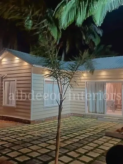 The same prefab farmhouse villa seen at night. The exterior lighting highlights the clean lines and creates a warm, inviting atmosphere, making it a perfect retreat.