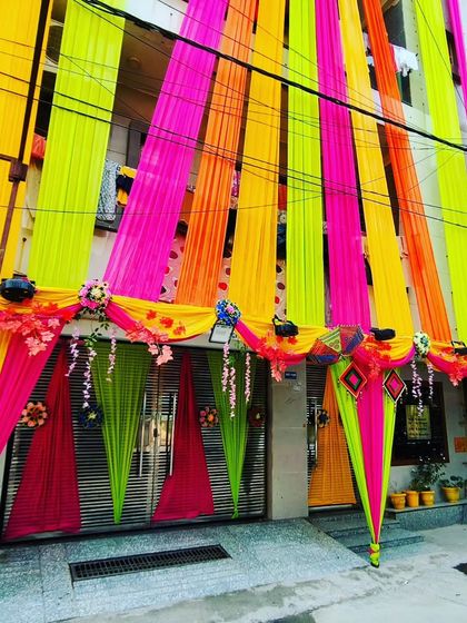 A vibrant, multi-coloured house front decoration using neon shades of green, pink, and yellow for a truly eye-catching display.