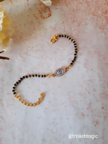 Protection meets elegance with this evil eye mangalsutra bracelet. The traditional black beads are paired with a sparkling evil eye charm, making it a perfect modern accessory.