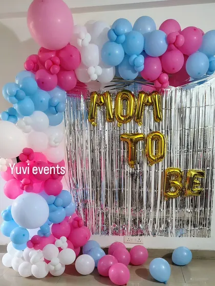 A 'Mom to Be' photo backdrop. I used a silver foil curtain and a pink, blue, and white balloon garland to create a festive spot for photos.