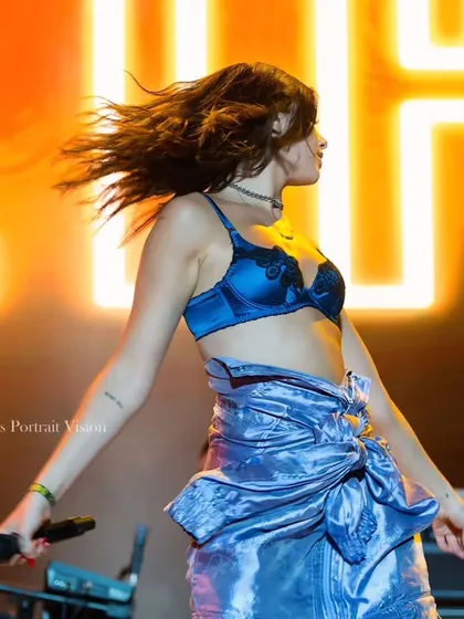 Capturing motion and energy as Dua Lipa performs. The hair flip and dynamic pose make this a lively and engaging concert photo.