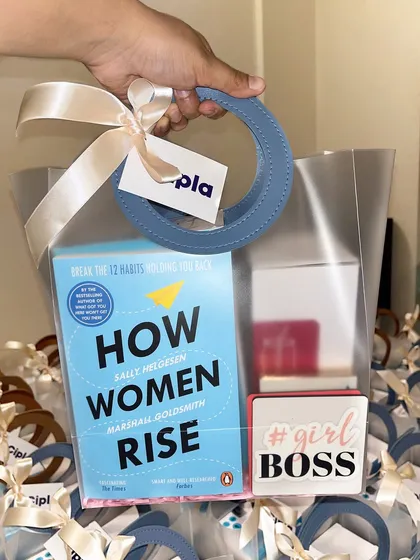 Gifting for a cause. For a Women's Day event at Cipla, we curated these modern gift bags featuring the book "How Women Rise" and other empowering goodies, demonstrating our ability to create themed gifts with a meaningful message.