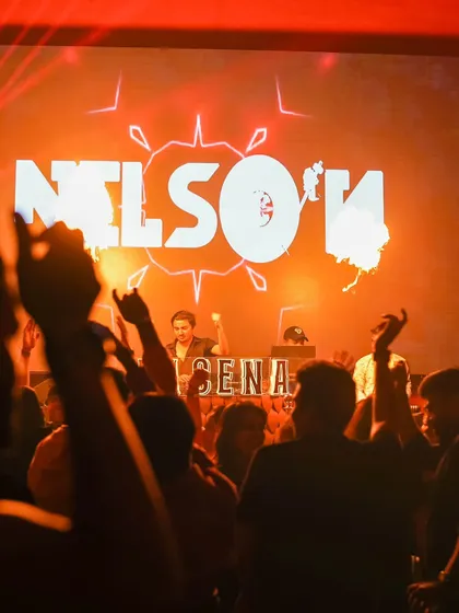 My custom logo lit up behind me as I control the music and the energy, with fire effects adding to the intensity of the moment.