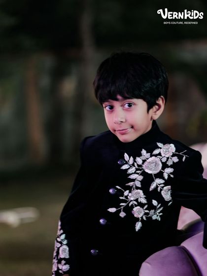 A quiet moment of style. This close-up shot captures the handsome profile of a young client in our black velvet embroidered jacket, perfect for a wedding reception.