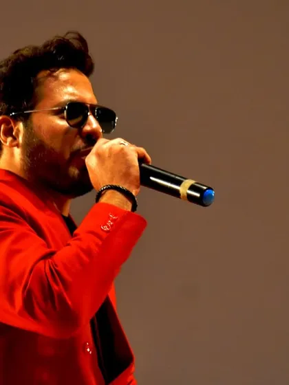 In action, on the mic in Patna. The red blazer reflects the high-octane energy of the event.