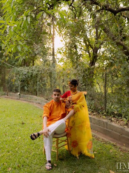 A stylish couple portrait taken in a lush garden setting. The composition and natural light highlight the couple's elegance during their Haldi ceremony at Oleander Farms.