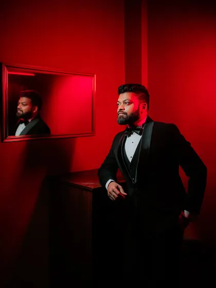 A dapper portrait of the groom in a classic tuxedo, captured with dramatic red lighting for a modern and stylish look. This showcases my creative approach to groom portraiture.