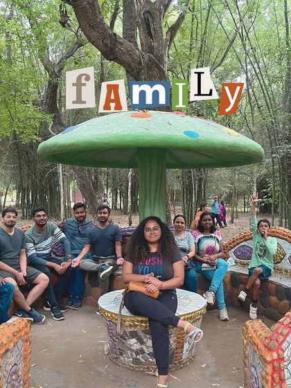 Our travel family relaxing under a mushroom-shaped shelter in a park in Coorg.