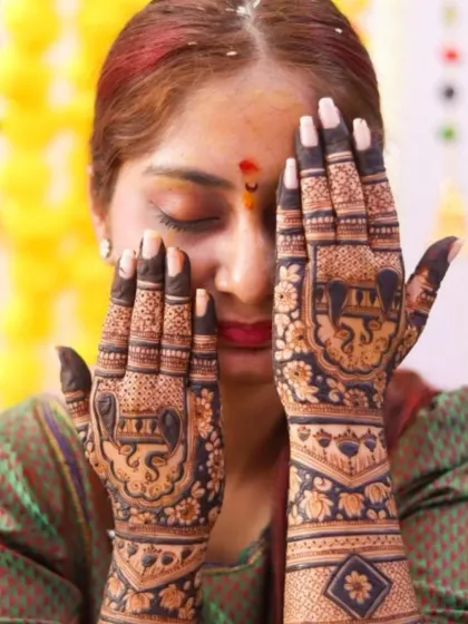 The bride's face is partially hidden, drawing all attention to the intricate elephant designs on her palms.