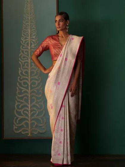 A handwoven Banarasi saree with a delicate pink border, paired with a contrasting brocade blouse. This look is a testament to classic Indian textile artistry.
