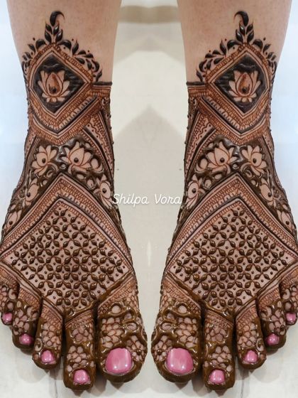 A full coverage bridal foot design with lotus flowers and dense geometric patterns, matching a full bridal hand design.