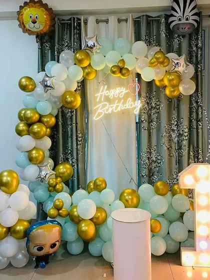 A different angle of the Boss Baby themed birthday decor. The "Happy Birthday" neon sign adds a warm glow to the setup.